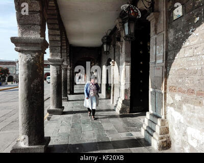 Indigene Frau, die am Ayacucho Plaza de Armas / Casona Boza y Solís spazieren geht Stockfoto