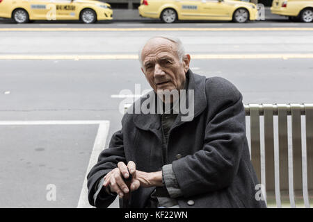 Alter Mann auf der Bank in der Stadt Stockfoto