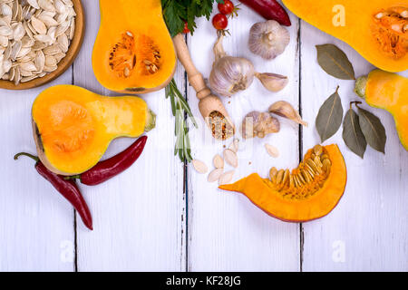 Frische Kürbis- und Kürbiskernen auf weißem Hintergrund Holz, leeren Raum an der Unterseite, Ansicht von oben Stockfoto