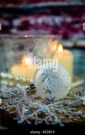 Silberne Weihnachtskugel und brennende Kerzen Dekoration Stockfoto