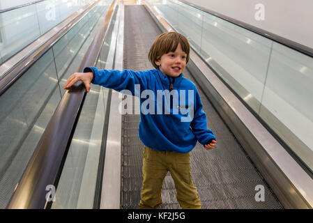 Jungen auf der Rolltreppe Stockfoto