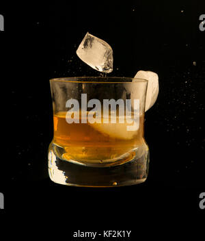 Eis fallen auf ein Glas Whiskey ein Spritzen, Flüssigkeit schwebenden Stockfoto