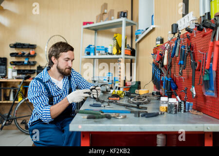 Junge Mechaniker eingehüllt in Arbeit Stockfoto