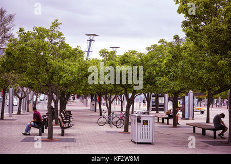 Der Sydney Olympic Park railway station öffentlichen Innenhof mit Bäumen und Fahrrad Parks und Leute sitzen auf Bänken. Platz der Stadt in Australien. Stockfoto