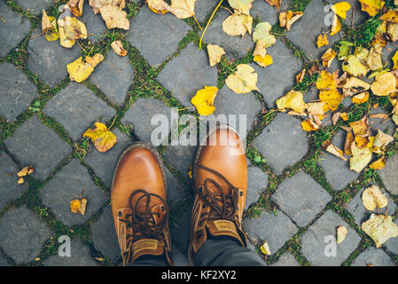 Mann Stiefel Draufsicht mit gelben Blätter im Herbst Stockfoto