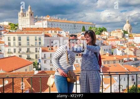 Frauen Freunde Selfie, zwei junge Frauen im Urlaub machen ein Selfie-Foto vor der Kulisse der Altstadt von Alfama in Lissabon, Portugal. Stockfoto