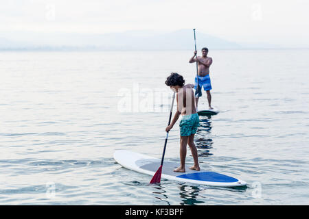 Junge und weiter üben bis Paddles stand Stockfoto