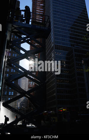 Arbeiter auf eine Scherenarbeitsbühne in new york city Stockfoto