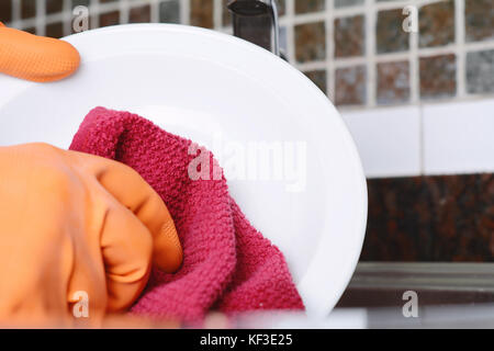 Nahaufnahme der Hände in Gummihandschuhe Geschirr mit Schwamm. Hausarbeit Konzept Stockfoto