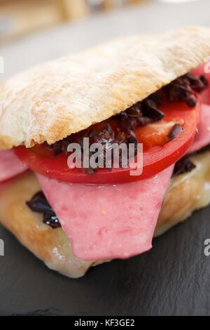 Mortadella Sandwich, Tomaten und schwarzen Oliven. Stockfoto