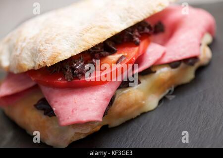 Mortadella Sandwich, Tomaten und schwarzen Oliven. Stockfoto