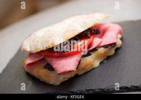 Mortadella Sandwich, Tomaten und schwarzen Oliven. Stockfoto