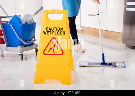 In der Nähe von Yellow wet Warnschild auf nassem Boden in der Küche Stockfoto