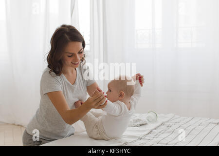 Mutter, Kind auf einem weißen Hintergrund zu sitzen Stockfoto