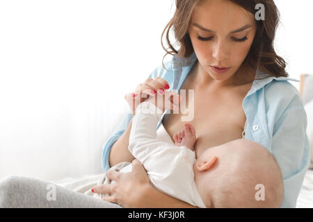 Mutter, Kind auf einem weißen Hintergrund zu sitzen Stockfoto