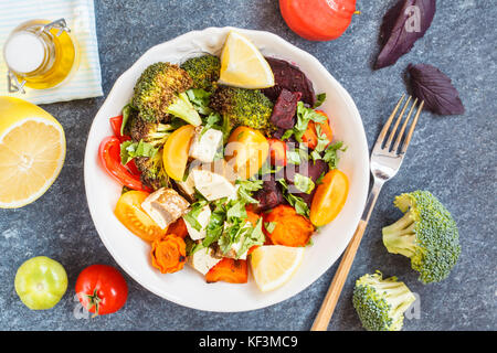 Vegetarische Salat mit gebackenem Gemüse und Tofu, Ansicht von oben, dunklen Hintergrund. Stockfoto