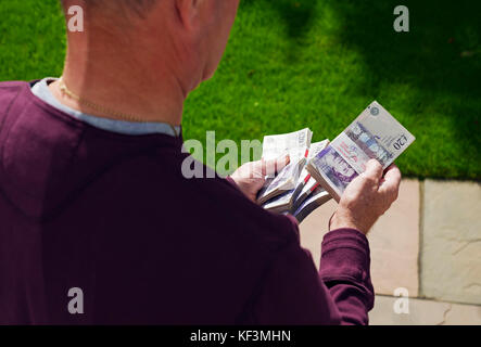 Nahaufnahme von Mann Person hält Bündeln von englischem Geld £20 zwanzig Pfund-Banknoten Banknoten Banknoten Bargeld England Vereinigtes Königreich GB Großbritannien Stockfoto