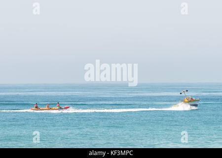 Menschen, die auf dem Bananenboot im Meer reiten. Stockfoto