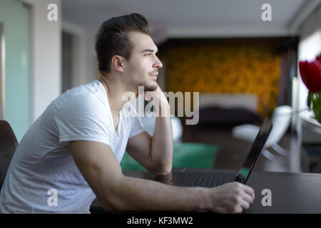 Junge legerer Mann Aufmerksamkeit ablenken von der Arbeit am Laptop Stockfoto