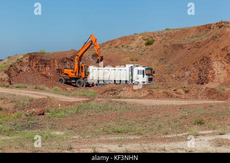 Bagger belädt einen LKW. Stockfoto