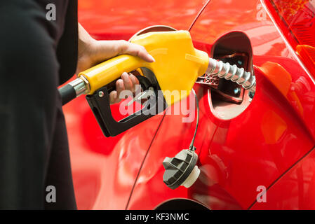 Nahaufnahme der Hand Geschäftsfrau tanken das Auto Tank mit Benzin Pumpe Düse Stockfoto