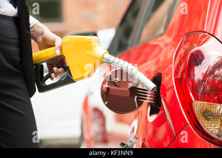 Nahaufnahme der Hand Geschäftsfrau tanken das Auto Tank mit Benzin Pumpe Düse Stockfoto