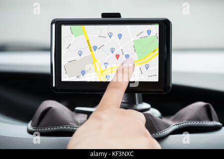 Nahaufnahme der Hand des Weiblichen mit GPS Navigation im Auto Stockfoto