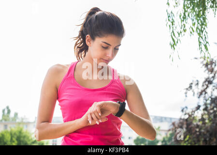 Frau Einrichten der Fitness Smart Watch für den Betrieb Stockfoto