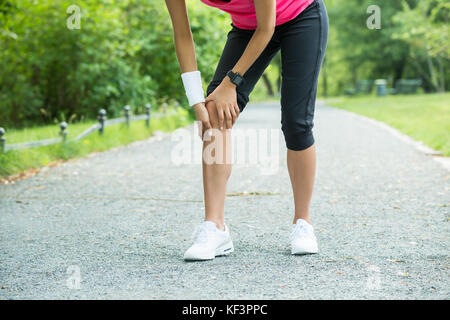 In der Nähe der weiblichen Jogger mit Schmerzen im Knie Stockfoto