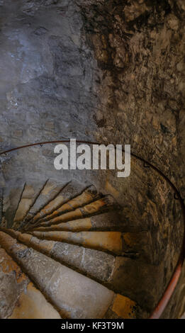 Dungeon Wendeltreppe hinunter. Zeigt wunderschön beleuchtet alte Schritte. Stockfoto