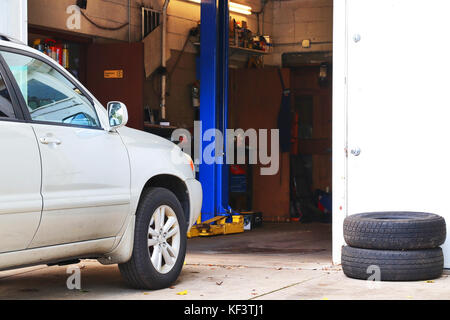 Auto warten auf Check-up vor dem kleinen Auto Service Shop. Auto Reparatur und Service Hintergrund. Stockfoto