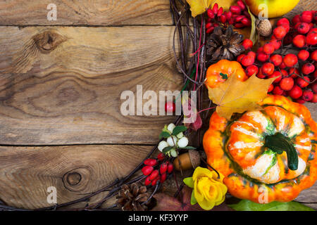 Danksagung Hintergrund mit dekorativen Kürbis, rote Vogelbeeren und gelbe Rose Wreath auf den Holztisch, kopieren Raum Stockfoto