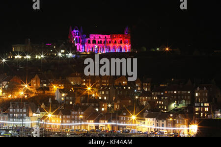 Whitby Abbey von English Heritage, das vom 25. Bis 31. Oktober sieben Tage lang beleuchtet wurde, mit der Küstenstadt Whitby in North Yorkshire im Vordergrund. Stockfoto