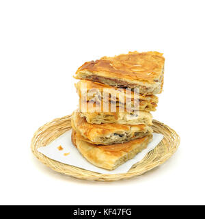 Geschmack Sorte Stack von knusprigem burek oder Kuchen auf einem Papier Serviette in einem Korb oder Brot Korb über weißen Hintergrund Stockfoto