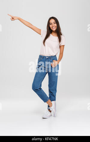 Portrait Of Happy asiatische Frau stehen und zeigenden Finger weg an Kopie Raum auf weißem Hintergrund Stockfoto