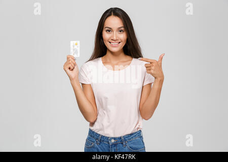 Porträt eines lächelnden gerne asiatische Frau in Brillen zeigen mit dem Finger auf eine Pille in Kunststoffabdeckung über weißem Hintergrund Stockfoto