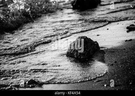 Ein Blick auf den See, Ufer, mit Details der Luftblasen im Wasser und Steine und Kiesel auf dem Sand Stockfoto