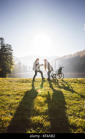 Senior Paar mit Rollstuhl im Herbst Natur. Stockfoto