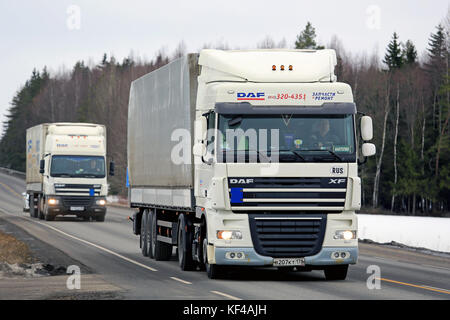 Kaarina, Finnland - 6. März 2016: zwei weisse Lkw Zug entlang der Autobahn. platooning bringt viele Vorteile, wie zum Beispiel Sicherheit und Kraftstoffeinsparung. Stockfoto