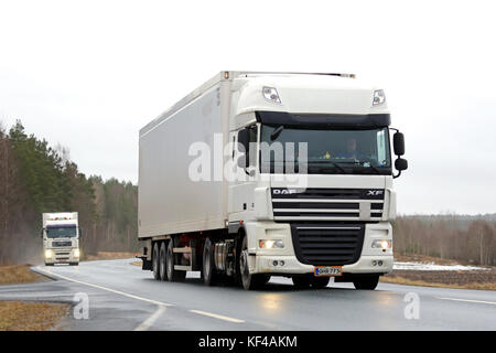 Salo, Finnland - Januar 30, 2016: Zwei weiße Lkw Transport entlang der Landstraße. Der Import im Hafen von Helsinki weiterhin im Wachsen Stockfoto