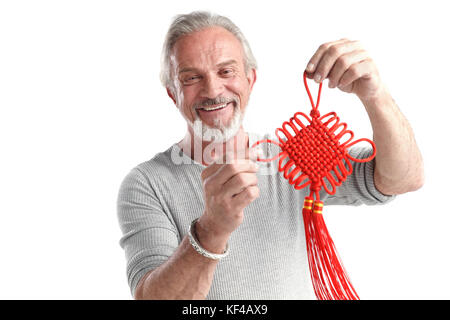 Der alte Mann hält den chinesischen Knoten Stockfoto