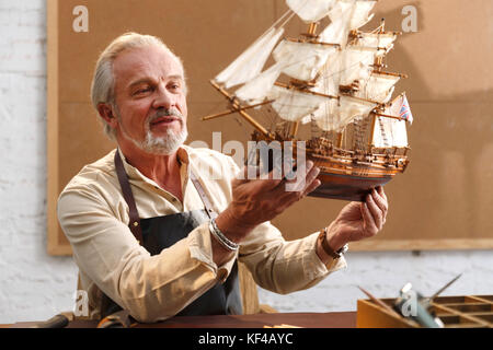 Der alte Mann ist ein Segelboot Modell Stockfoto