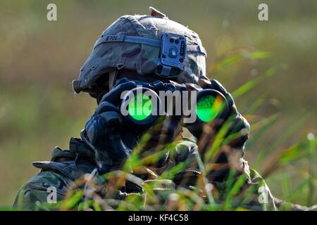 Ein Soldat der US-Armee scannt den Horizont mit einem Fernglas während der Übung Dragon im Bemowo Piskie Training Area am 26. September 2017 in der Nähe von Orzysz, Polen. Stockfoto