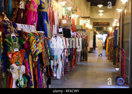 Bunte östlichen Kleider außerhalb ein Geschäft am Warren von überdachten Gassen in Souq Waqif, Doha angezeigt, im Oktober 2017. Stockfoto