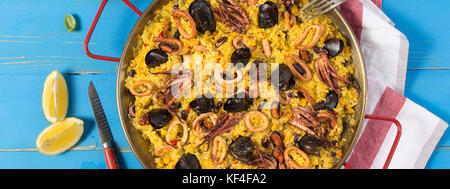 Spanische Meeresfrüchte Paella in traditionellen Pfanne auf rustikalen Holztisch Stockfoto