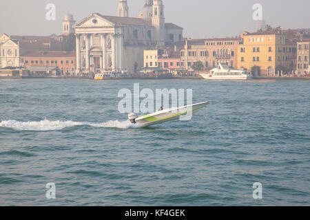 Mann Beschleunigung in einem Motorboot, Canale della Giudecca, Venedig, Italien Reisen so schnell im Licht Nebel, der die ganze Boot angehoben ist klar von Wasser Stockfoto