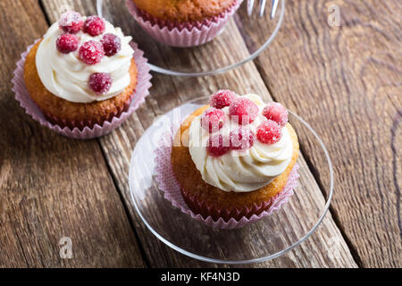 Kandierte Preiselbeeren und Rahm Käse hausgemachte Muffins auf Holzbrett. hausgemachte Herbstferien Dessert auf rustikalen Tisch Stockfoto