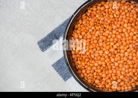 Rote Linsen in einem Ton Schüssel mit einem Tuch Stockfoto