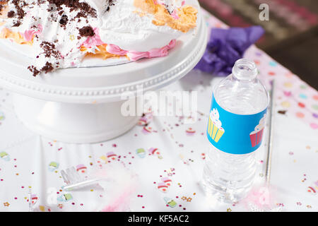 Kindergeburtstag Tisch mit Sahnigen Kuchen und eine Flasche Limo auf einem Hintergrund von Konfetti mit Kopie Raum sprengte Stockfoto