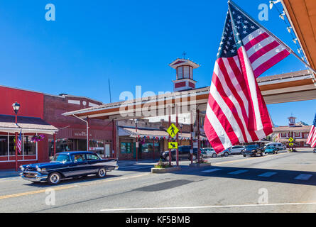 Amerikanische Flagge mit überdachtem Quersteg im Hintergrund auf der Cottage Ave in der Innenstadt von Cashmere, einer Stadt im Chelan County, Washington, USA Stockfoto